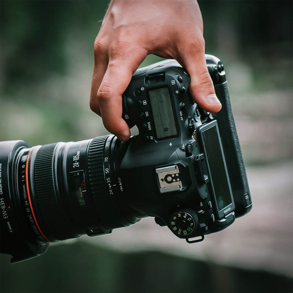 Fotógrafo mano sujetando cámara